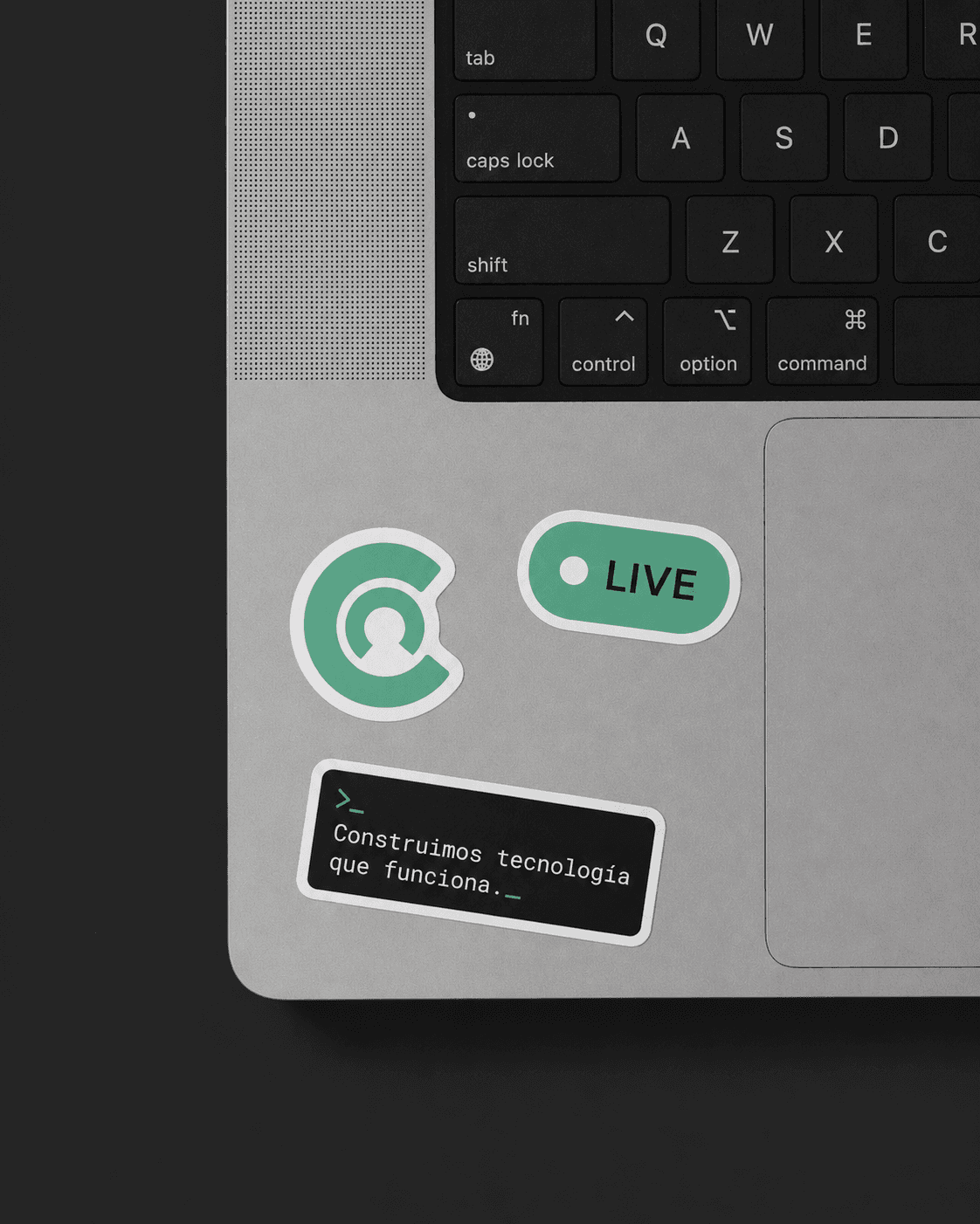 Laptop with Calímaco stickers: the logo mark, a «LIVE» badge and the tagline «We build technology that works».